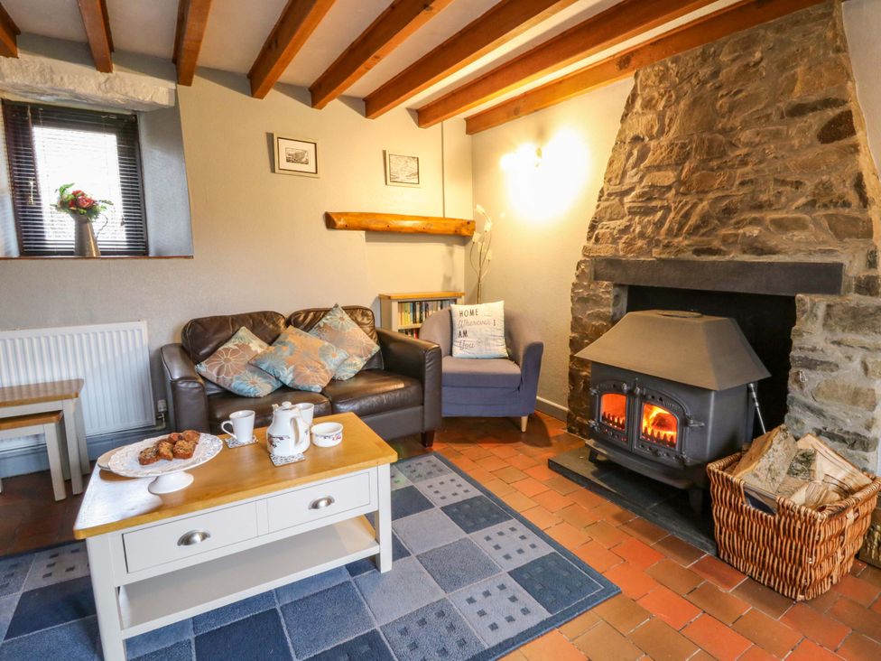A living room with a fireplace and seating at Old Farmhouse Cottage 