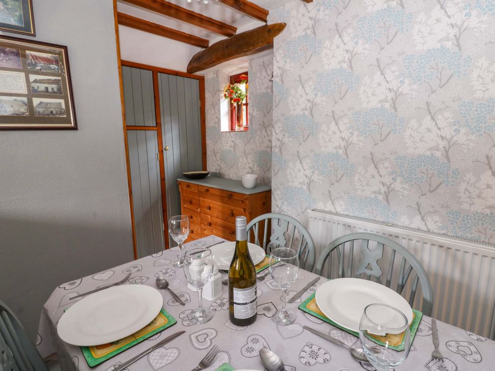 A dining room with a table set for a meal at Old Farmhouse Cottage