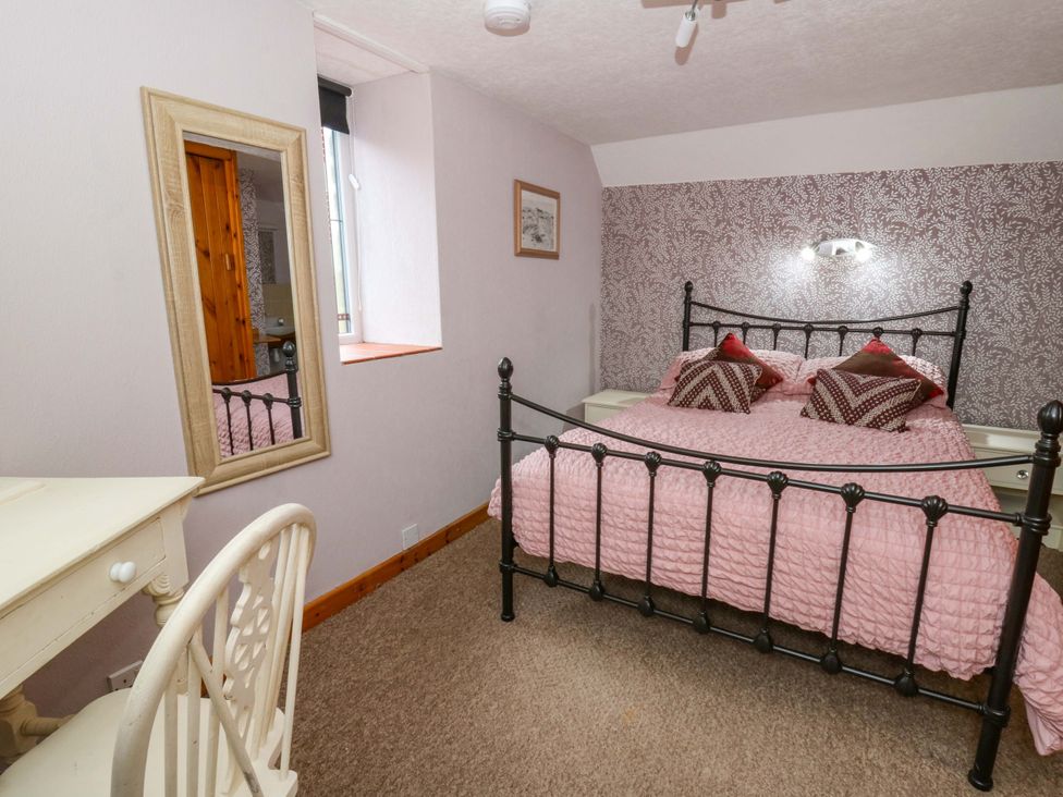 A bedroom with a bed and mirror at Old Farmhouse Cottage