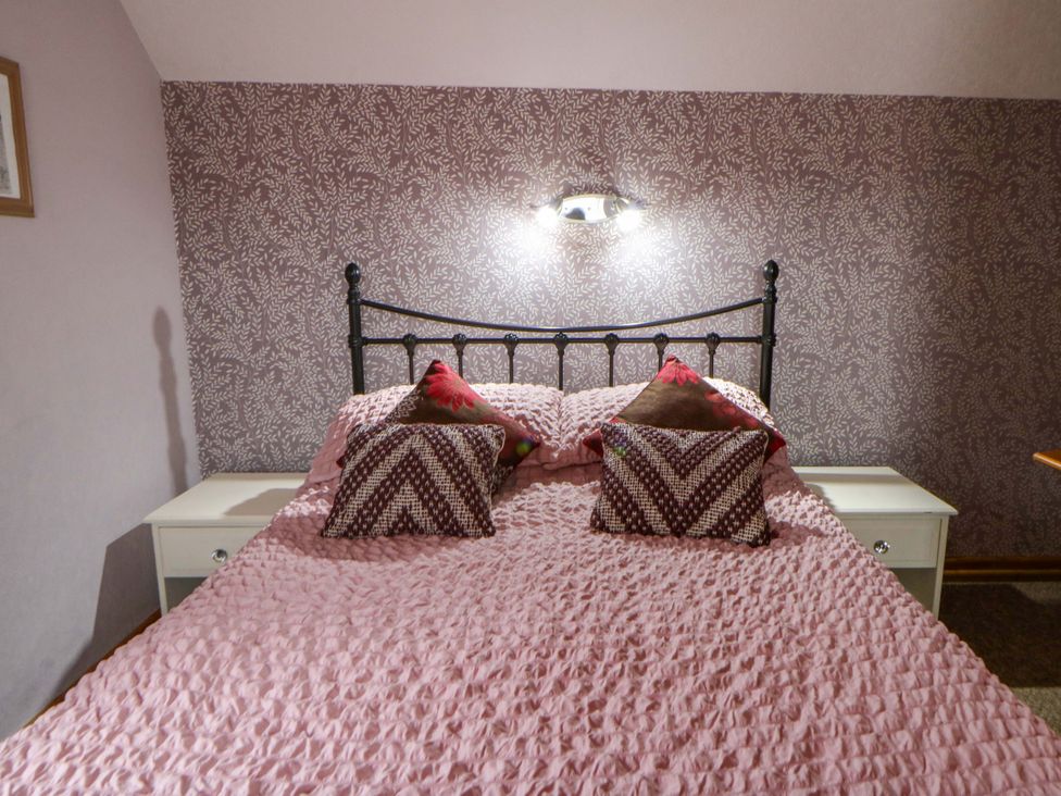 A bedroom with a bed and bedside table at Old Farmhouse Cottage