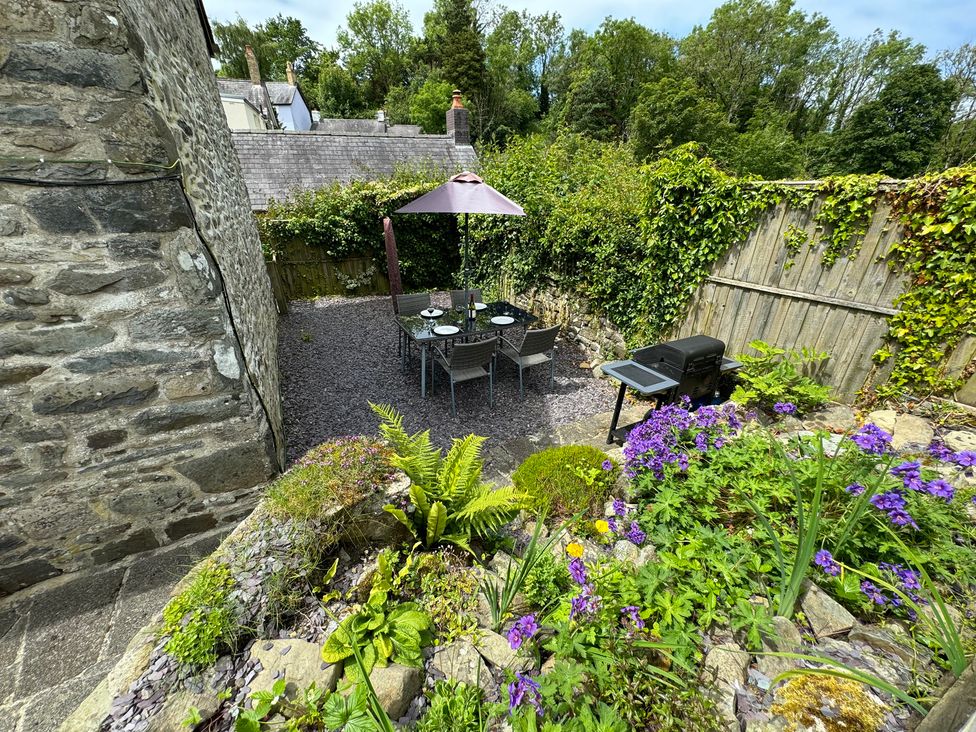 A garden with a dining set and grill at Old Farmhouse Cottage