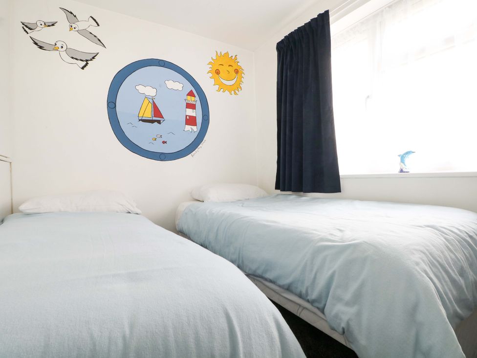 A bedroom with two beds and wall art at 38 St Margarets