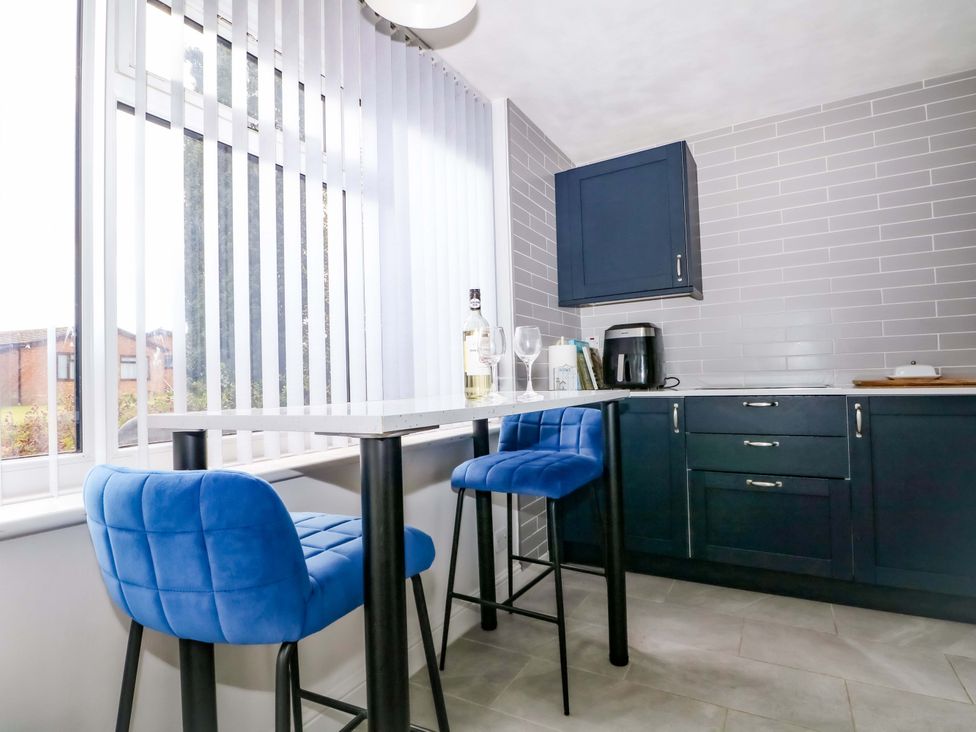 A kitchen with blue bar stools and a table at 38 St Margarets