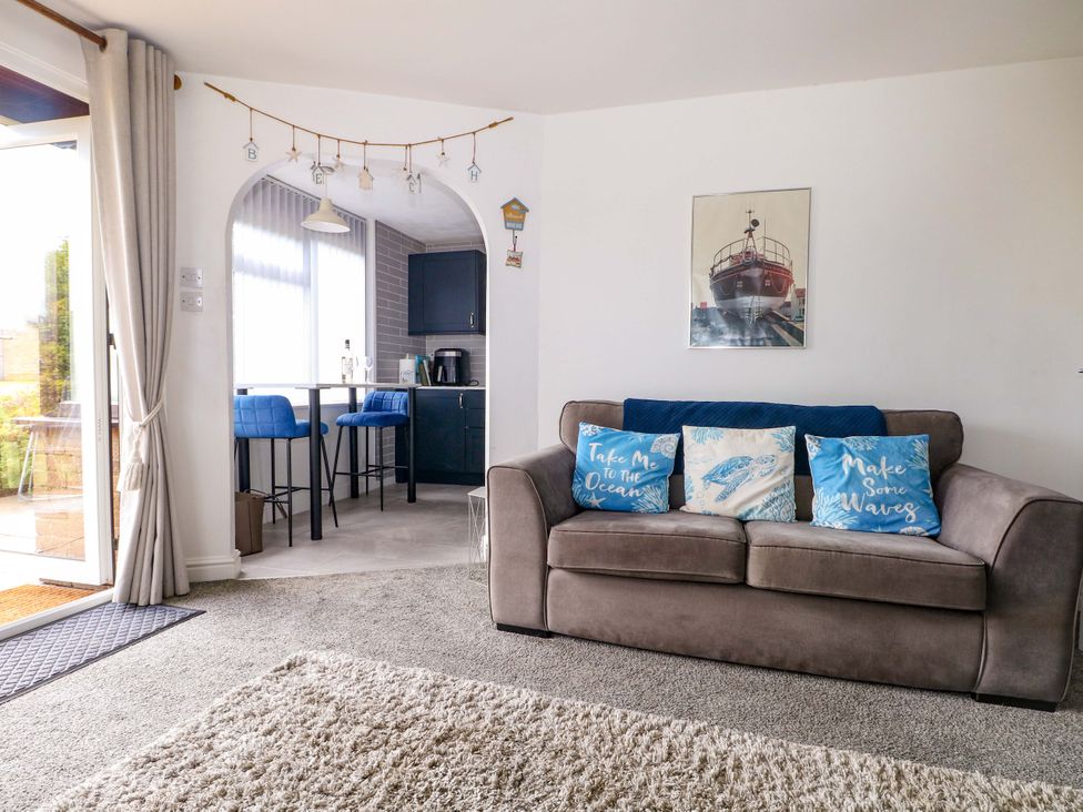A living room with a sofa and kitchen table at 38 St Margarets