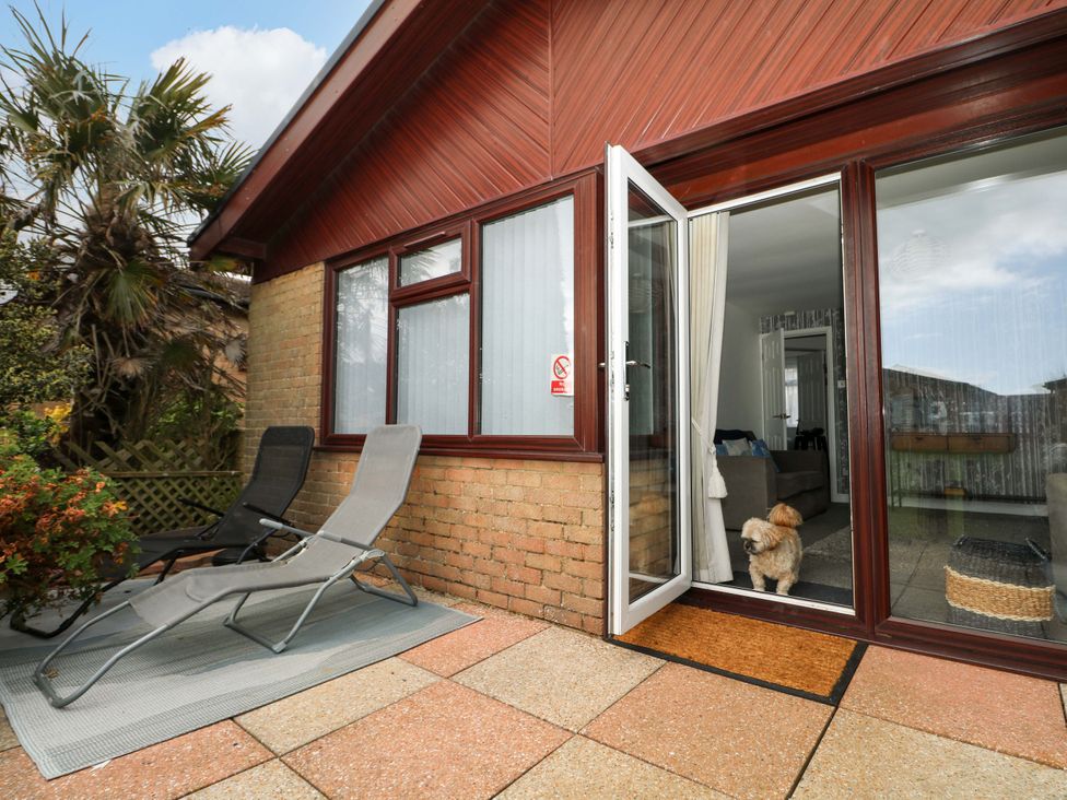 A patio with lounge chairs and a dog at 38 St Margarets