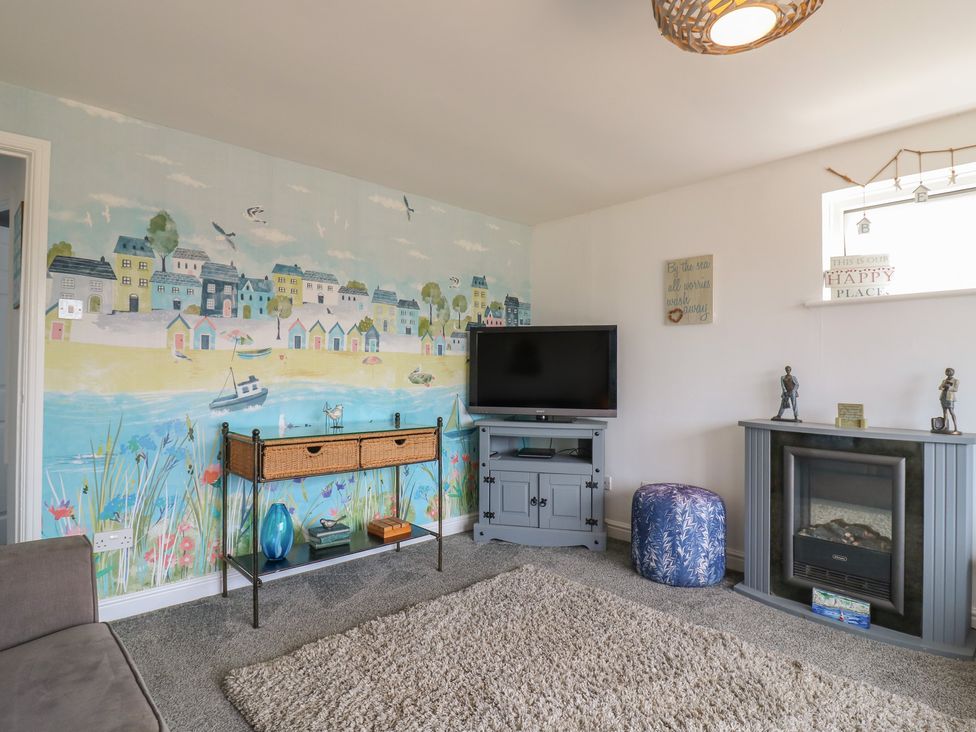 A living room with a television and a mural at 38 St Margarets in St Margaret's At Cliffe