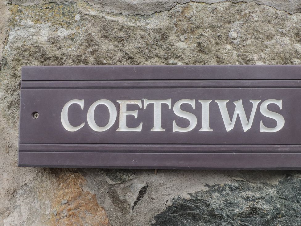 A sign reading Coetsiws mounted on a stone wall at Coetsiws in Clynnog Fawr