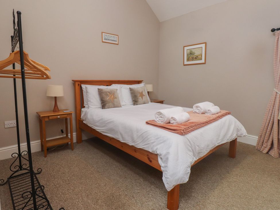 A bedroom with a bed and bedside table at Coetsiws in Clynnog Fawr