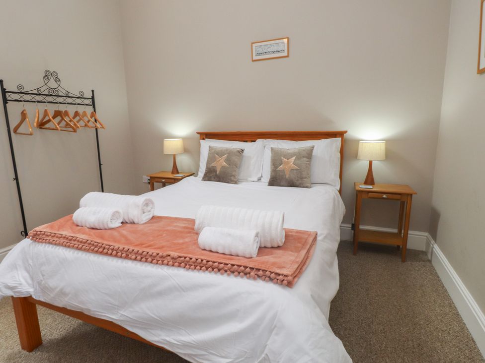 A bedroom with a bed and bedside tables at Coetsiws Clynnog Fawr