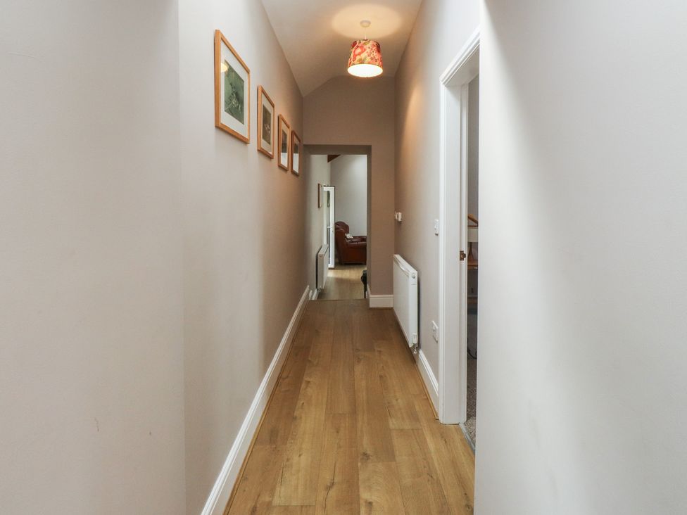 A hallway with floor and light fixture at Coetsiws in Clynnog Fawr