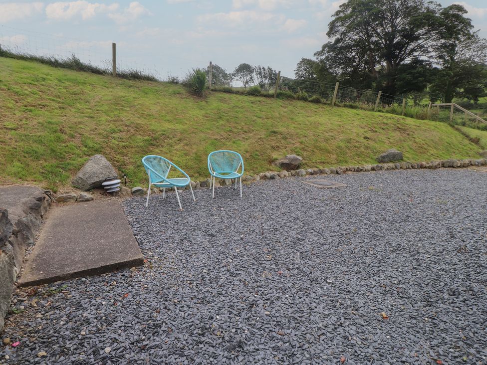 An outdoor area with chairs and gravel at Coetsiws Clynnog Fawr