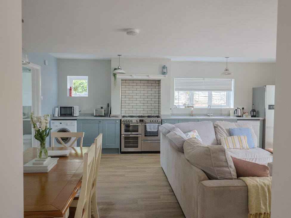 A kitchen with appliances and a dining table at Sunny Croft in Broadmayne near Dorchester