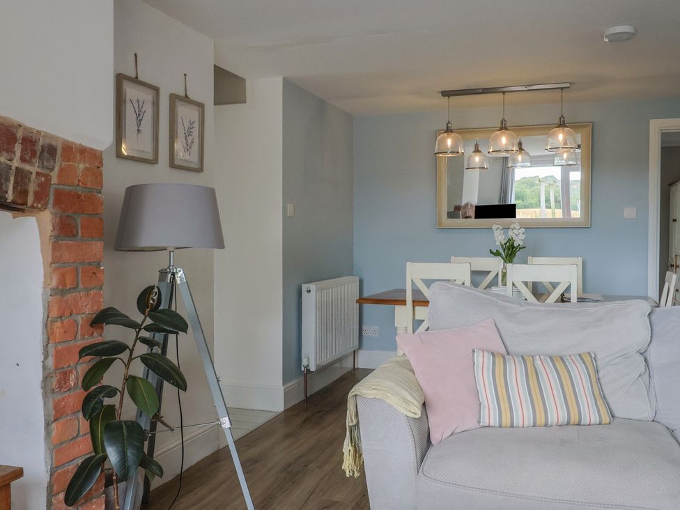 A living room with a sofa and dining area at Sunny Croft in Broadmayne near Dorchester