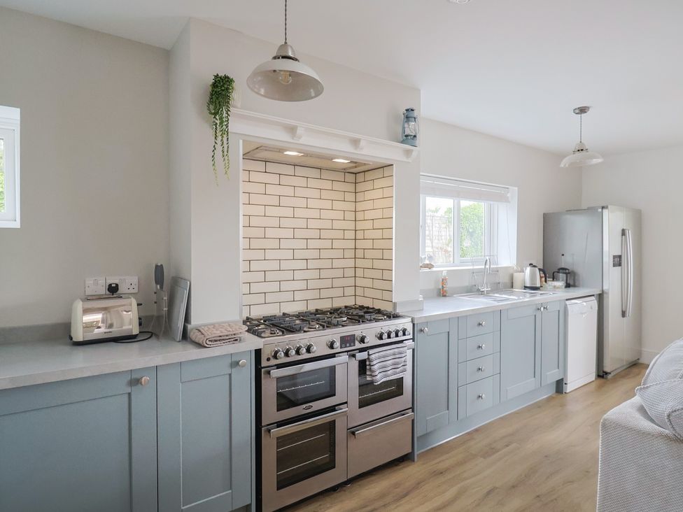 A kitchen with stove and refrigerator at Sunny Croft in Broadmayne near Dorchester