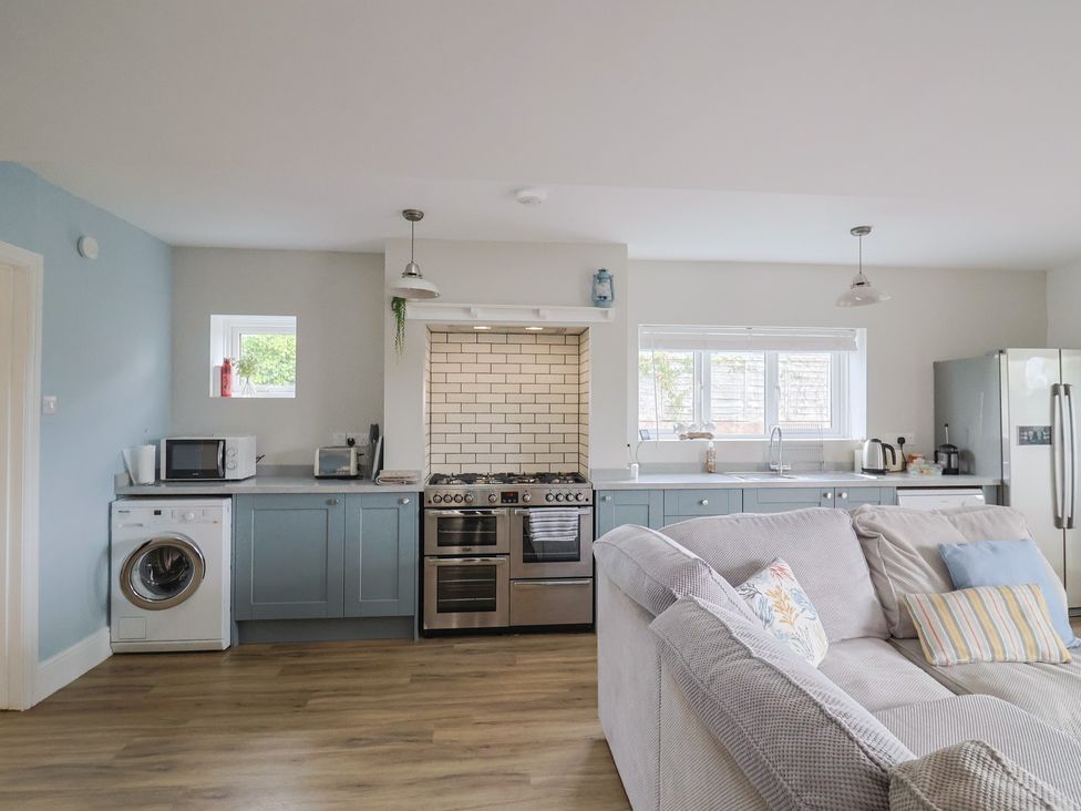 A kitchen with appliances and a couch at Sunny Croft in Broadmayne near Dorchester