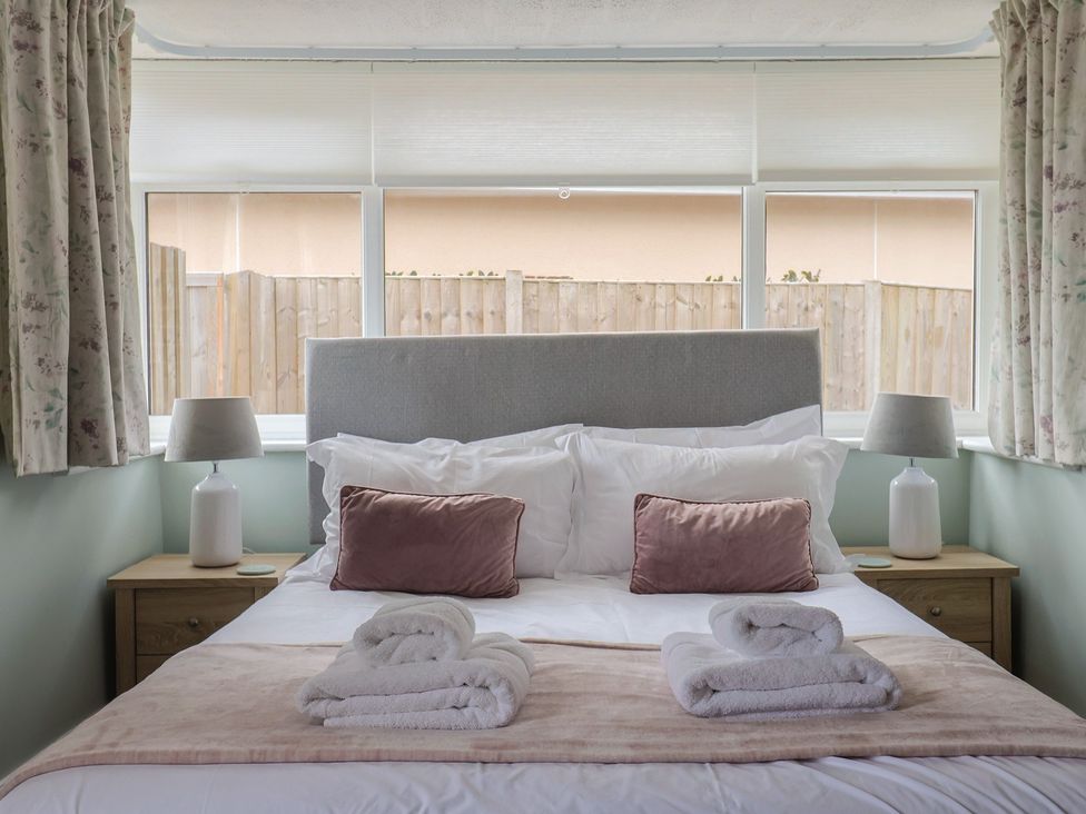 A bedroom with a bed and lamps on bedside tables at Sunny Croft in Broadmayne near Dorchester
