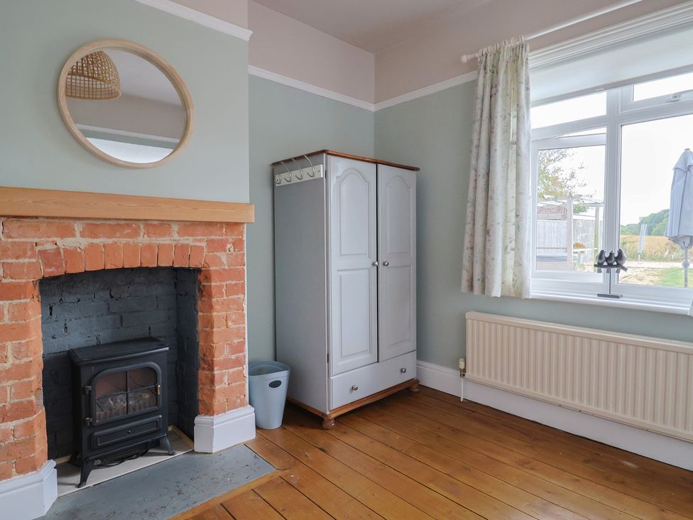A living room with a fireplace and wardrobe at Sunny Croft in Broadmayne near Dorchester
