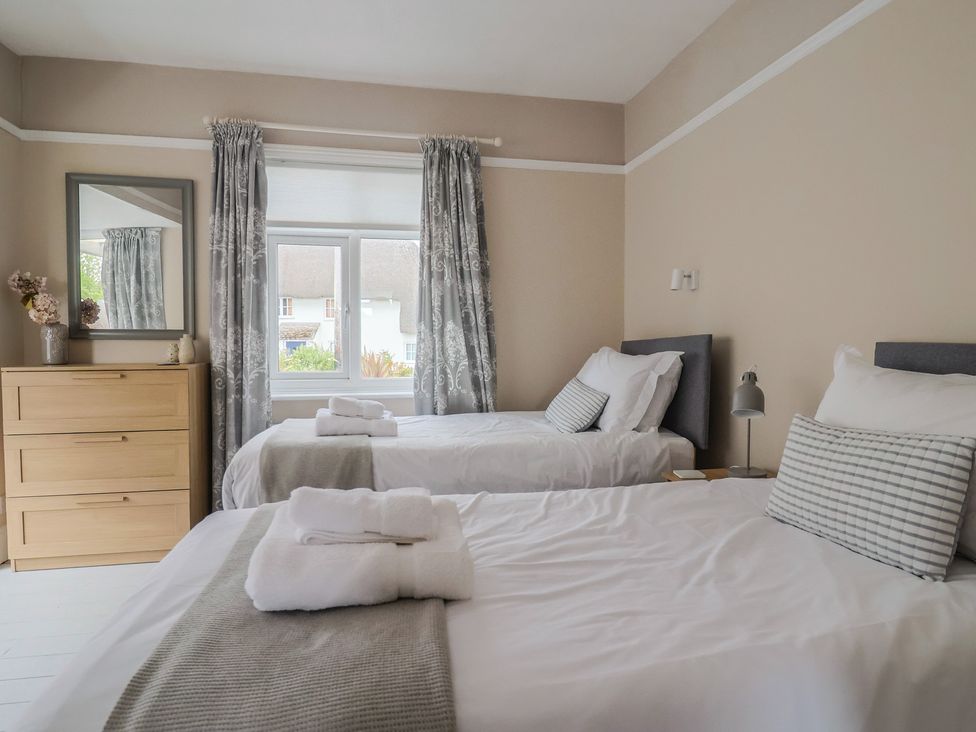 A bedroom with two beds and a dresser at Sunny Croft in Broadmayne near Dorchester