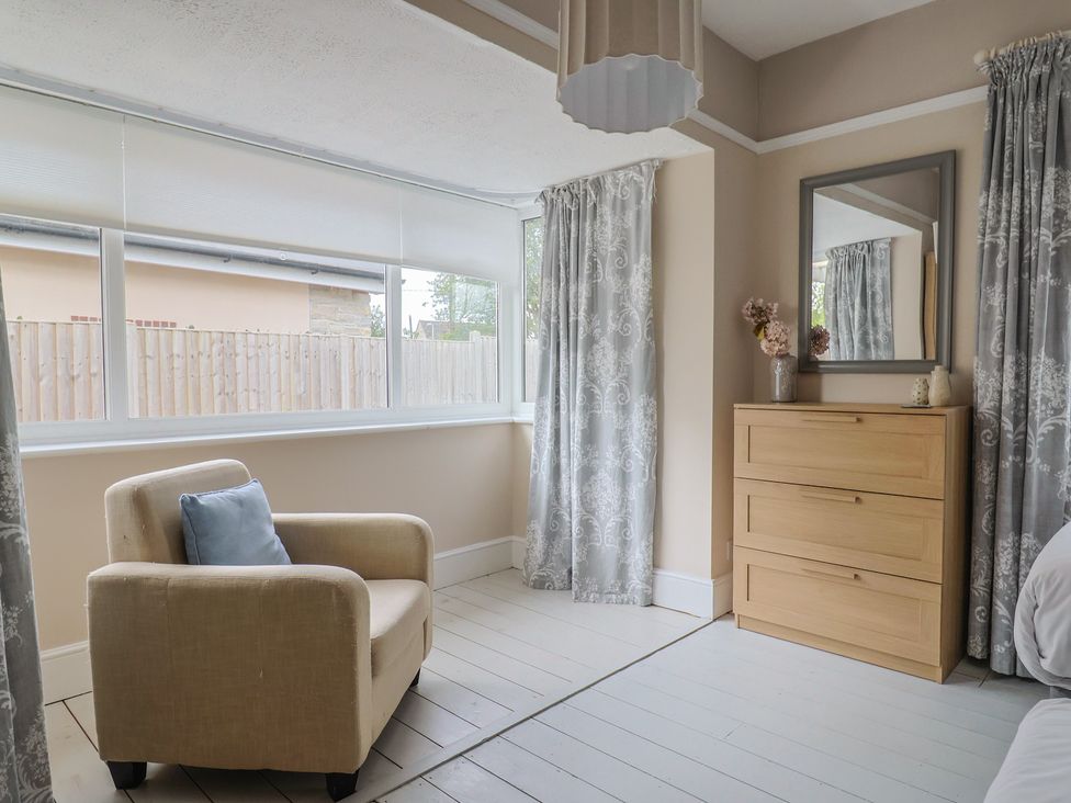 A bedroom with an armchair and dresser at Sunny Croft in Broadmayne near Dorchester