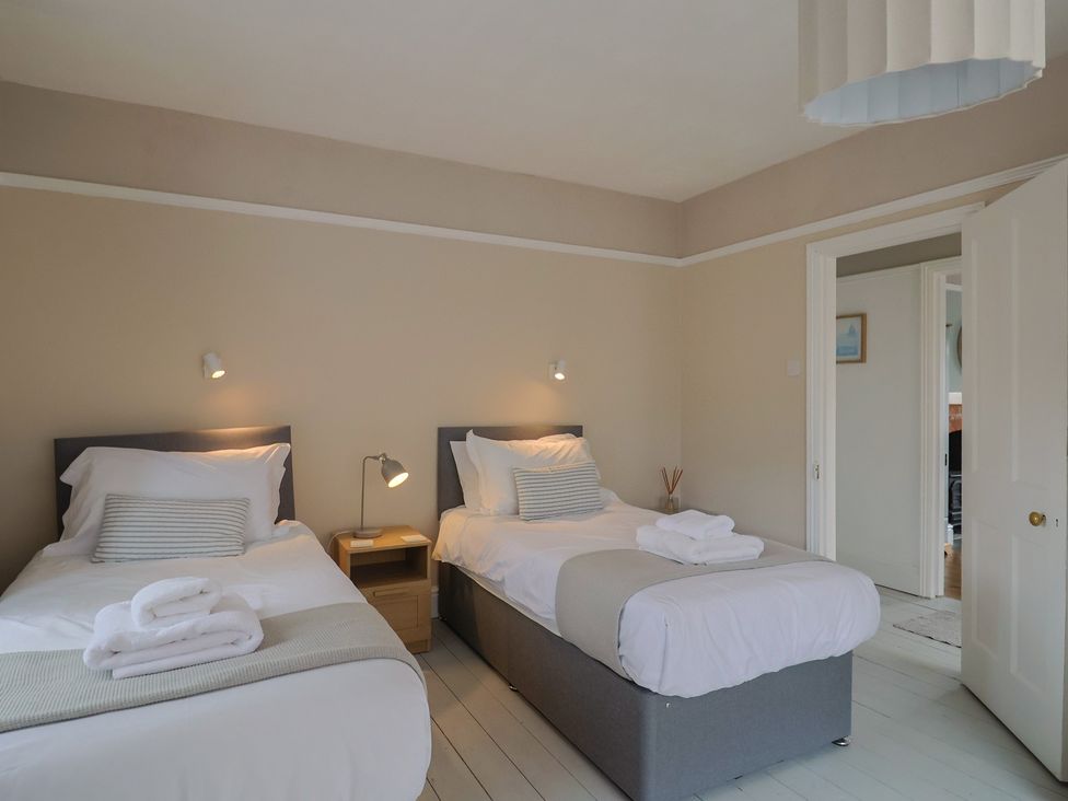 A bedroom with two single beds and a nightstand at Sunny Croft in Broadmayne near Dorchester