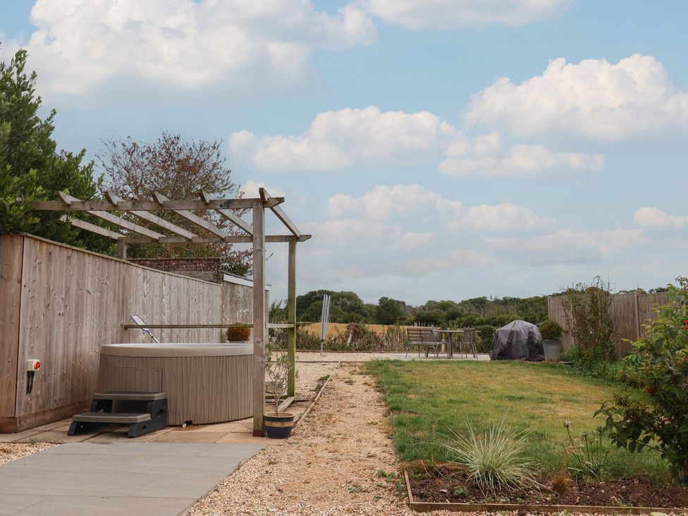 A garden with a hot tub and furniture at Sunny Croft in Broadmayne near Dorchester