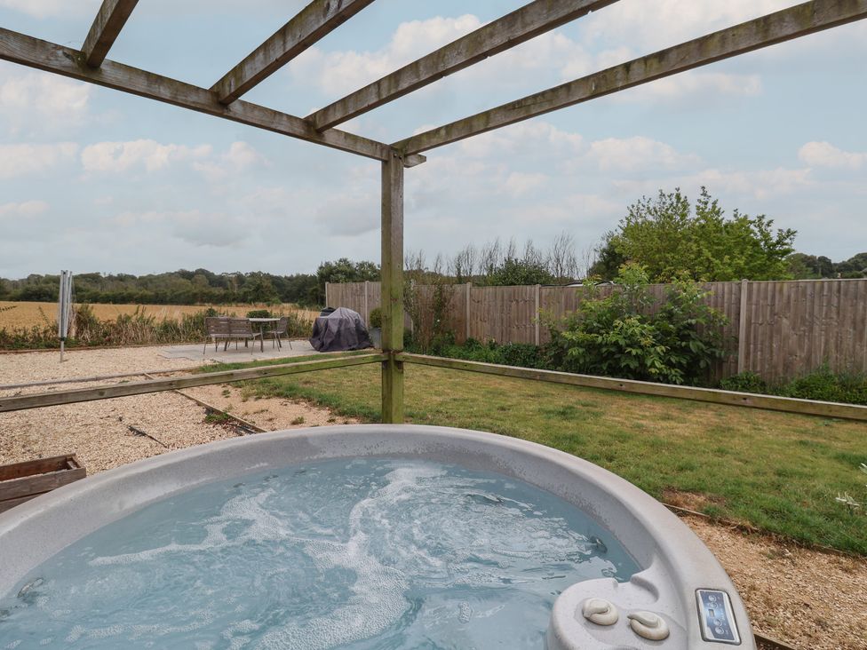 A garden with a hot tub and outdoor seating at Sunny Croft in Broadmayne near Dorchester