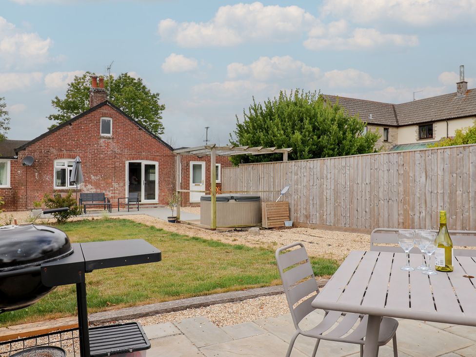 A garden with a barbecue and hot tub at Sunny Croft in Broadmayne near Dorchester
