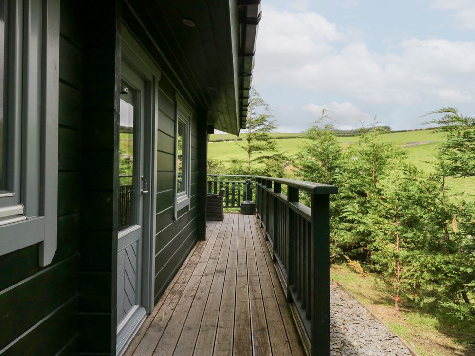 An outdoor area with a deck and trees at Oak Lodge in Pennington near Ulverston