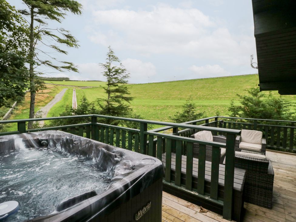 An outdoor area with a hot tub and seating at Oak Lodge in Pennington near Ulverston