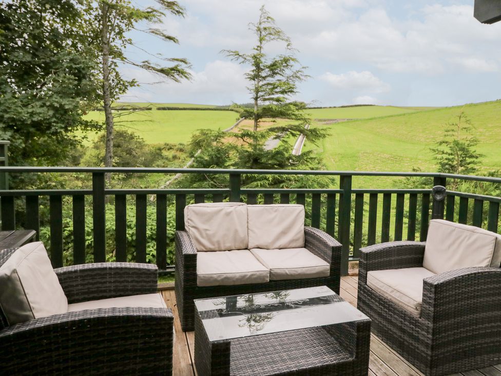 An outdoor seating area with couches and a coffee table at Oak Lodge in Pennington near Ulverston