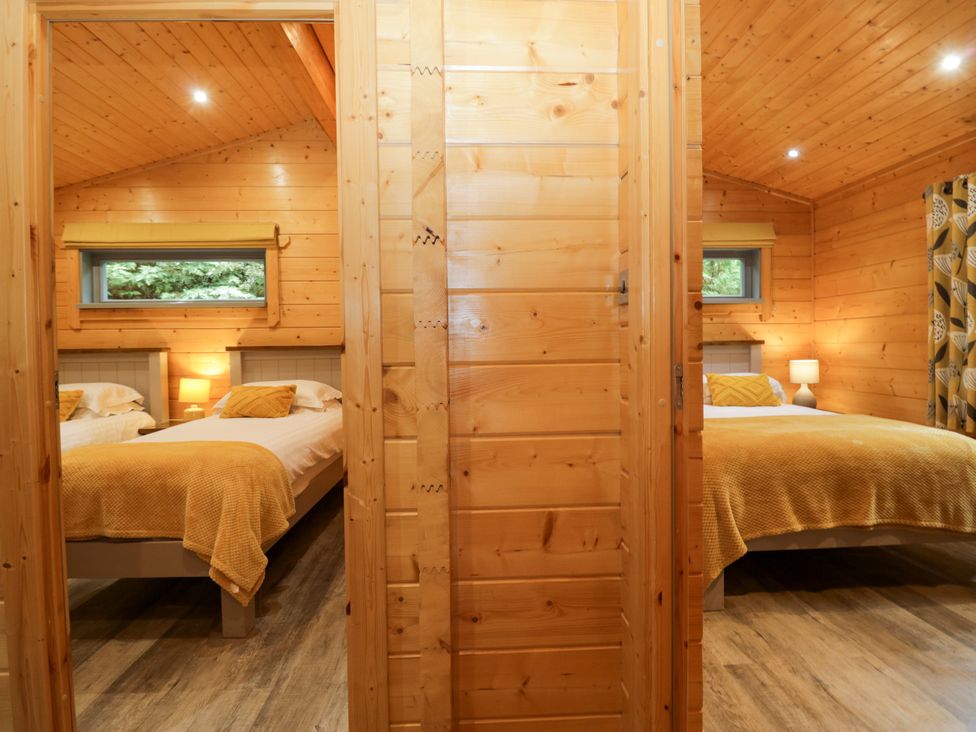 A bedroom with two beds and a window at Oak Lodge Pennington near Ulverston