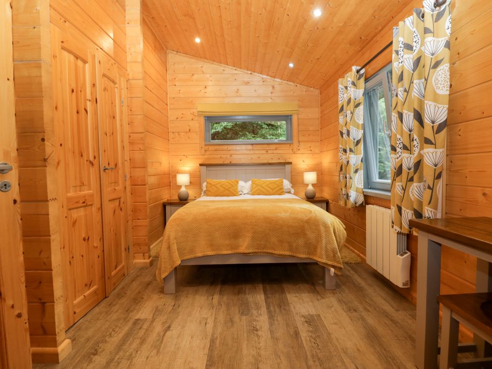 A bedroom with wood paneling and a bed at Oak Lodge Pennington near Ulverston