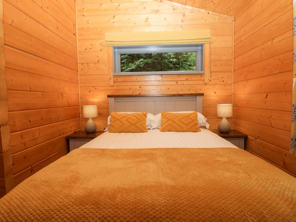 A bedroom with a bed and lamps at Oak Lodge in Pennington near Ulverston