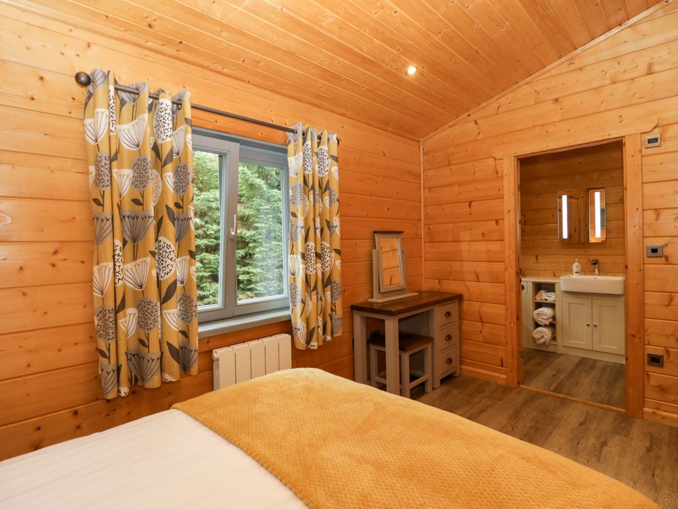 A bedroom with a bed and a bathroom area at Oak Lodge Pennington near Ulverston