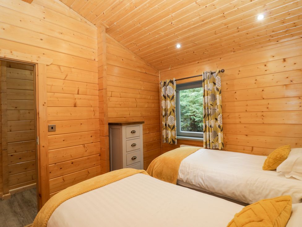 A bedroom with twin beds and a window at Oak Lodge Pennington near Ulverston