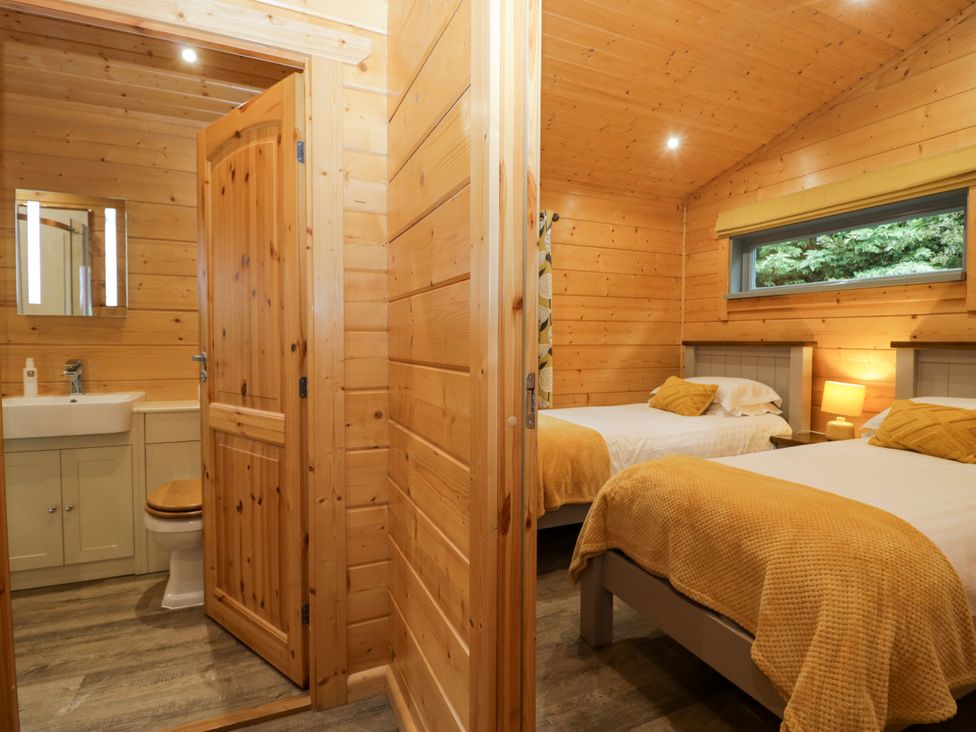 A bedroom with two beds and a bathroom at Oak Lodge Pennington near Ulverston