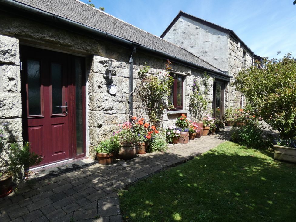 An outdoor entrance with flower pots and a pathway at Brunnion Cottage in St Ives