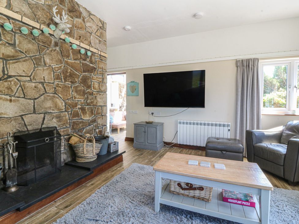 A living room with a television and fireplace at Tyn Morfa in Llangwnnadl near Aberdaron