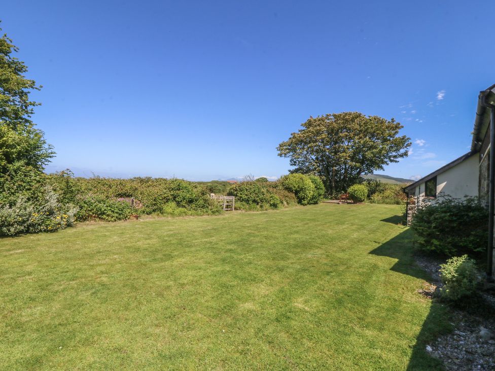 A garden with grass and a tree at Tyn Morfa in Llangwnnadl near Aberdaron
