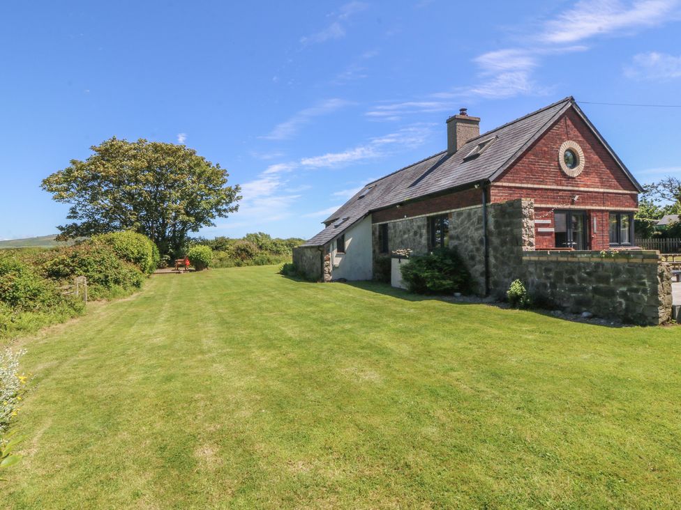 A house with a lawn and trees at Tyn Morfa in Llangwnnadl near Aberdaron