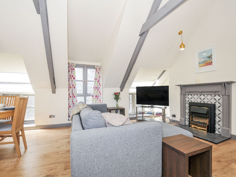 A living room with a couch and television at Beach Retreat in Looe