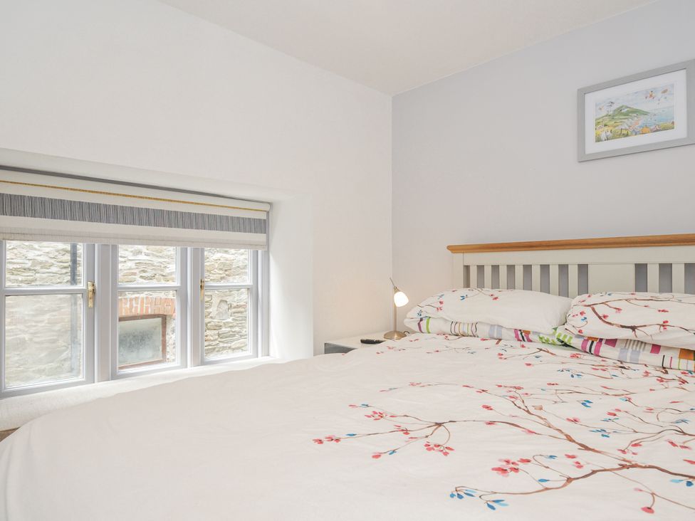 A bedroom with a bed and window at Beach Retreat in Looe
