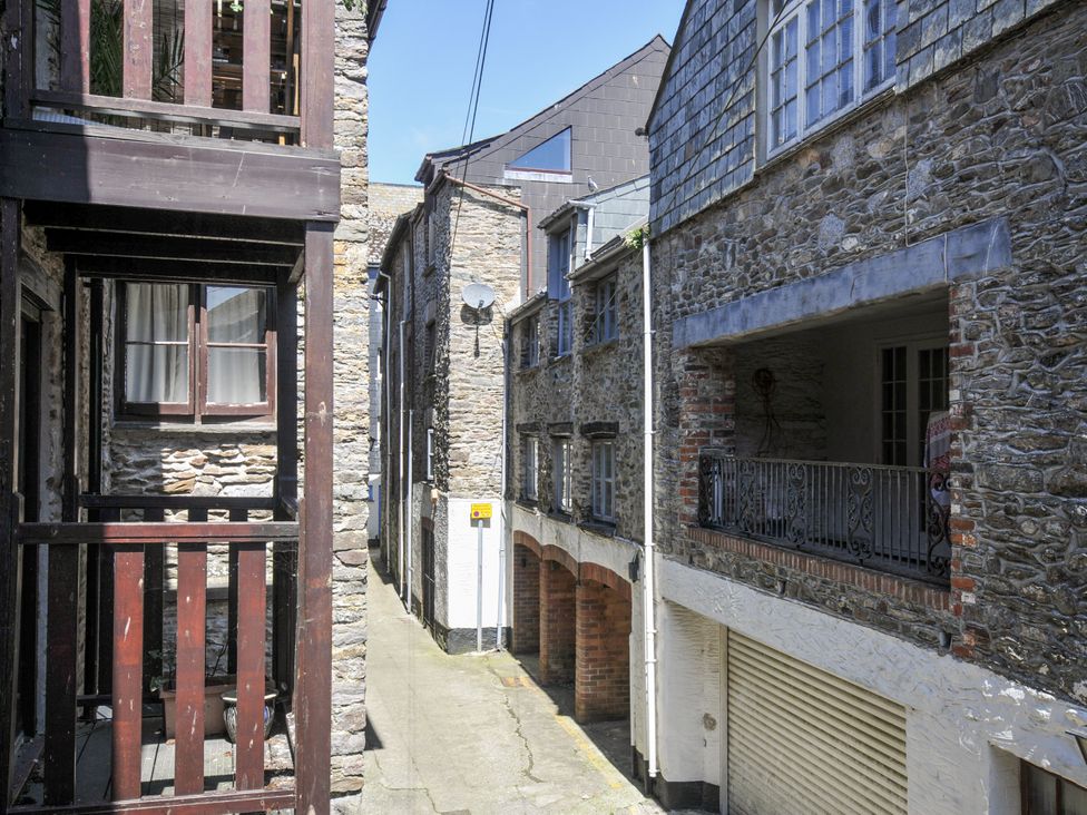 An outdoor alley with stone buildings and a balcony at Beach Retreat Looe