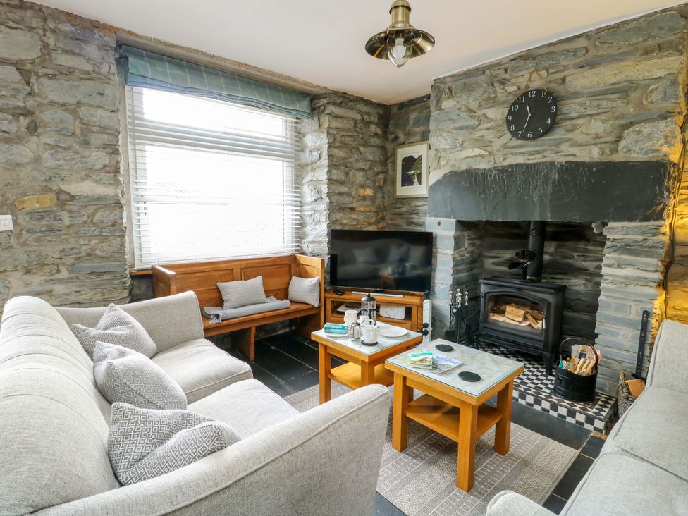 A living room with a sofa and fireplace at Garreg Ddu in Blaenau Ffestiniog