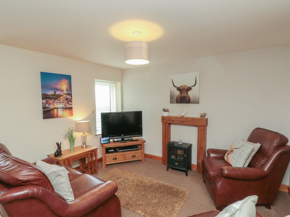 A living room with a tv and sofa at Milton Cottage in Hawsker near Whitby and Robin Hood's Bay