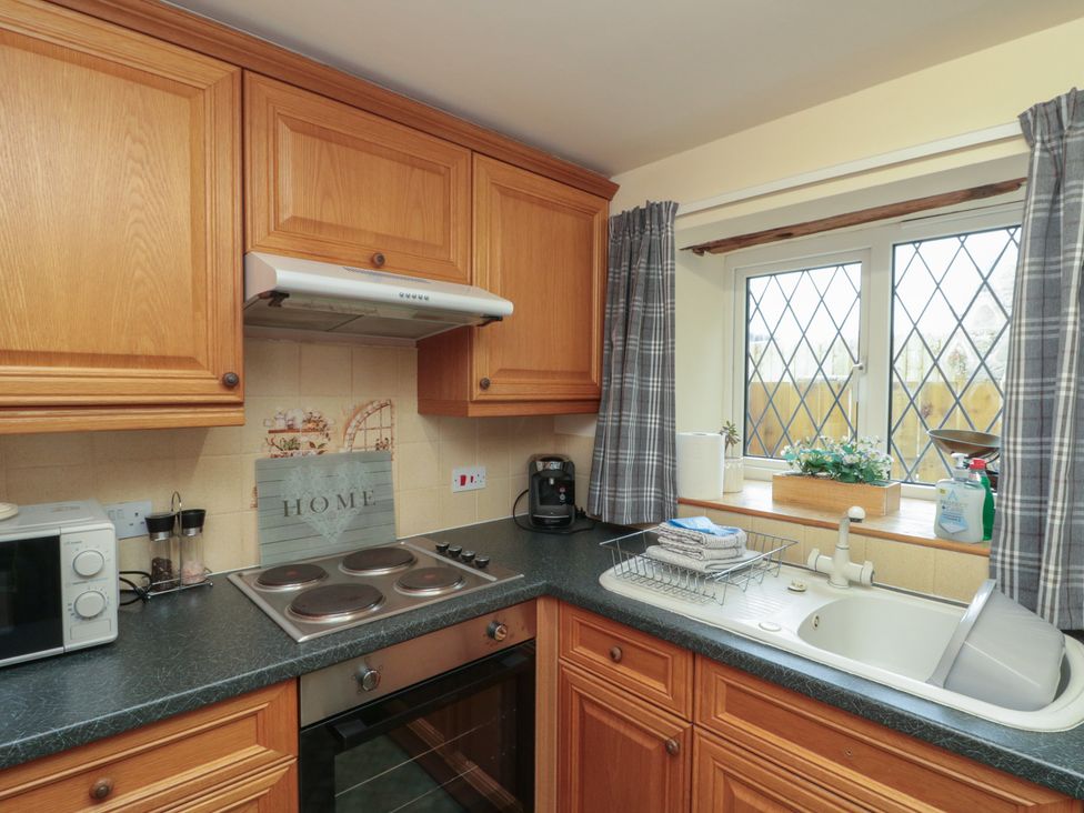 A kitchen with cabinets and appliances at Milton Cottage in Hawsker near Whitby and Robin Hood's Bay