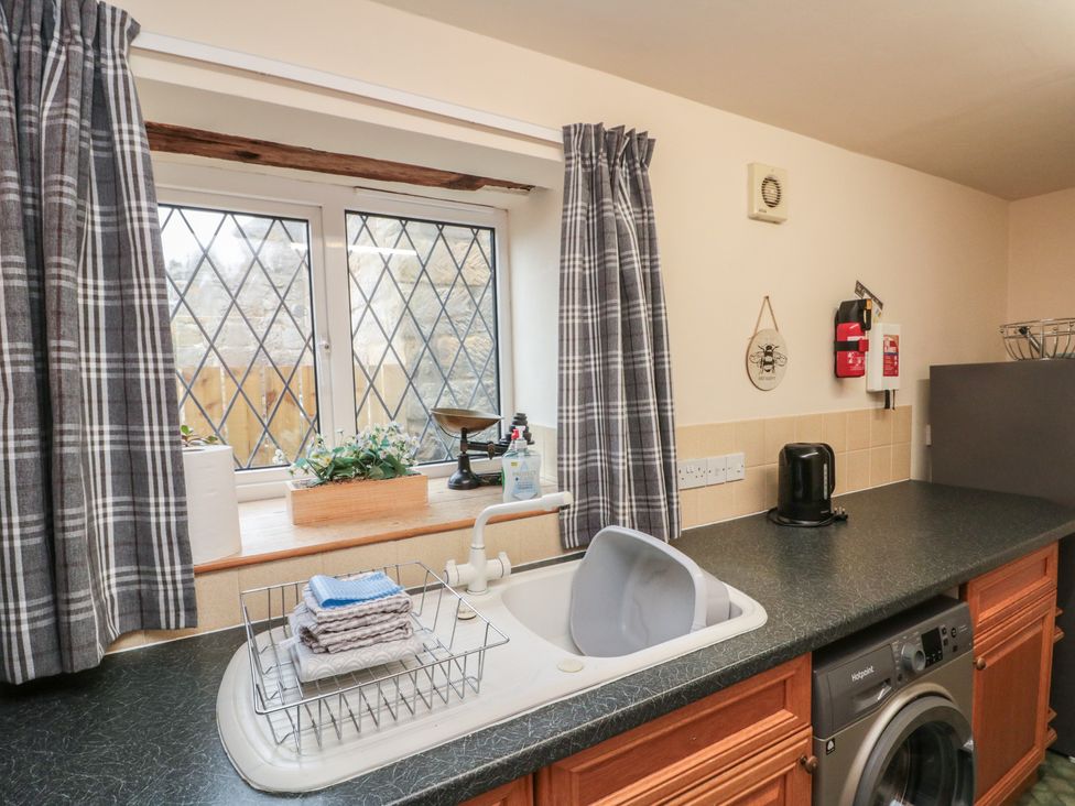 A kitchen with a washing machine and sink at Milton Cottage in Hawsker near Whitby and Robin Hood's Bay