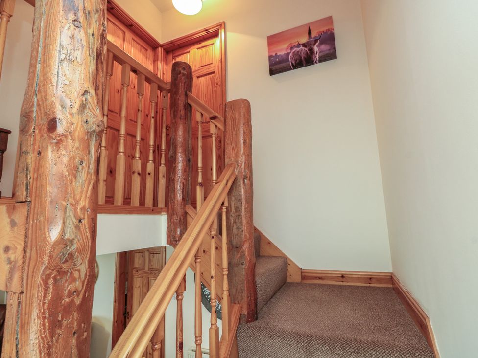 A staircase with wooden railings and a photo on the wall at Milton Cottage Hawsker near Whitby and Robin Hood's Bay
