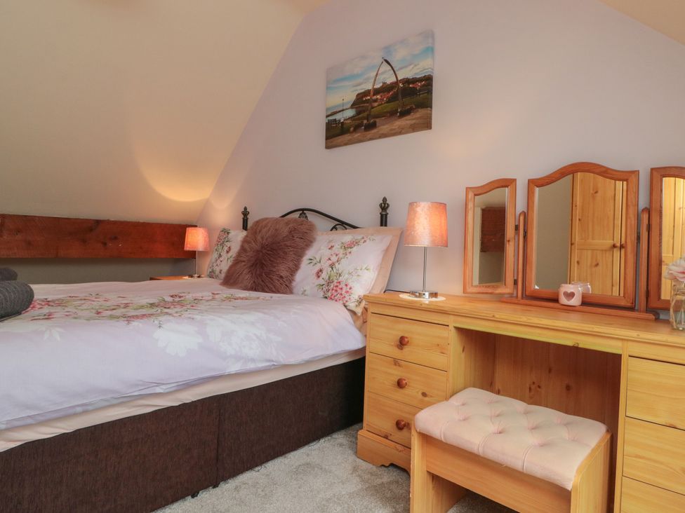 A bedroom with a bed and vanity table at Milton Cottage in Hawsker near Whitby and Robin Hood's Bay