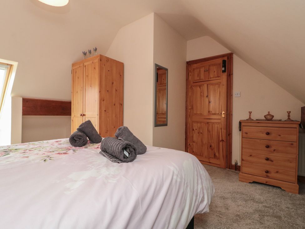 A bedroom with a bed and wardrobe at Milton Cottage Hawsker near Whitby and Robin Hood's Bay